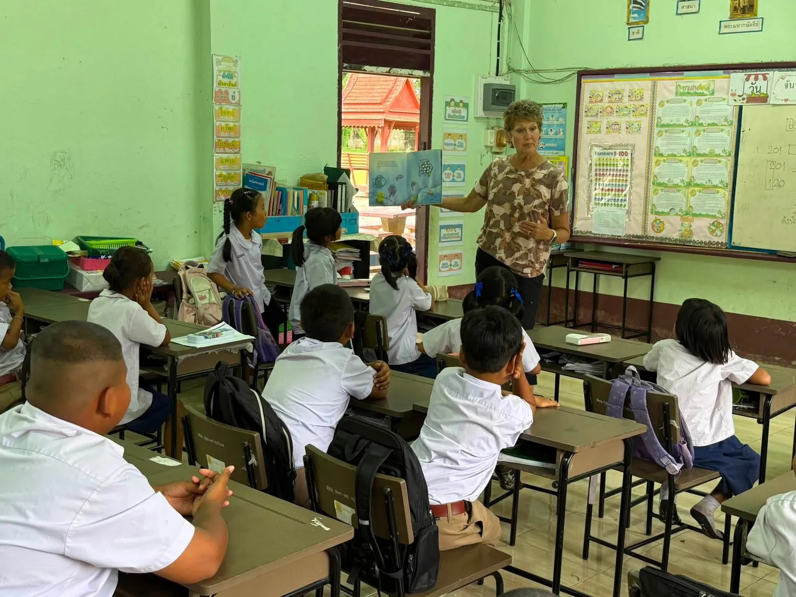 A volunteer teaches an English lesson to primary students in a Mae Sai classroom